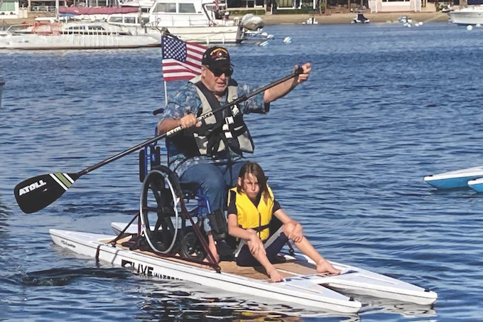 Vet with boy on SUP Veterans Relief Foundation